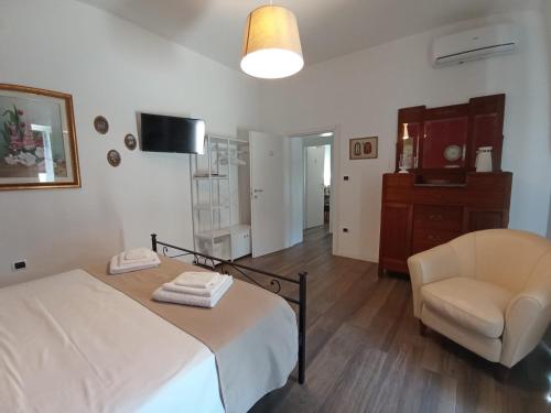 a bedroom with a bed and a chair in a room at Tenuta viale degli ulivi in San Martino in Pensilis
