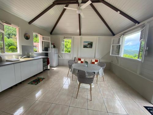 a kitchen with a table and chairs in a room at Le cocon de Cathy in Rivière-Pilote