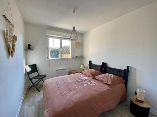 a bedroom with a bed and a window and a chair at Sea Breeze Gujan-Mestras in La Celle-sous-Gouzon