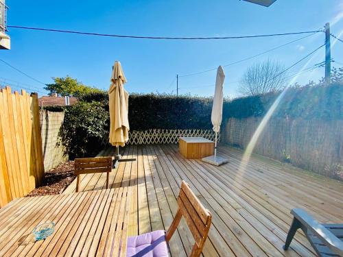 a wooden deck with two umbrellas and a bench at Sea Breeze Gujan-Mestras in La Celle-sous-Gouzon