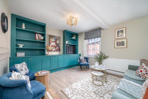 a living room with blue furniture and green cabinets at Victoria 2 bedroom flat - Buckingham palace in London