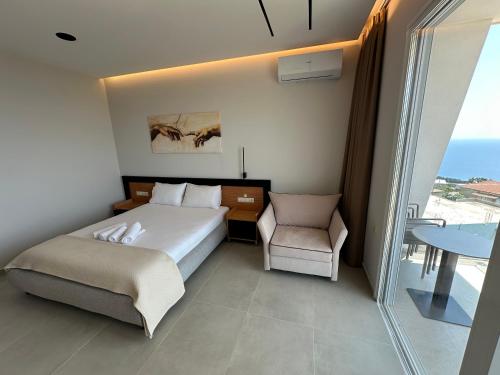 a bedroom with a bed and a chair and a table at Kalami Rooms Dhermi in Dhërmi