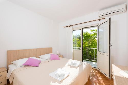a bedroom with a bed and a balcony at Apartments Nikola Stipišić in Hvar