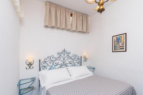 a white bedroom with a blue and white bed at Casa Vivì in Positano