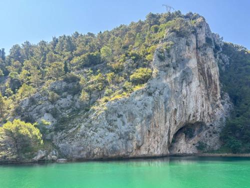 a mountain with a cave in the middle of a lake at Apartments Grbac Veli Rat-Seaside in Veli Rat