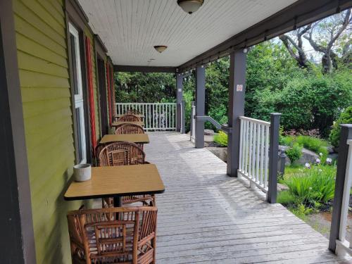 a row of tables and chairs on a porch at Auberge d'Anjou-Sūrya Café in Petit Rocher