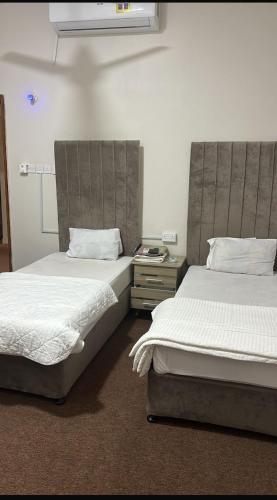 two beds sitting next to each other in a room at فندق ثمريت in Thamarīt