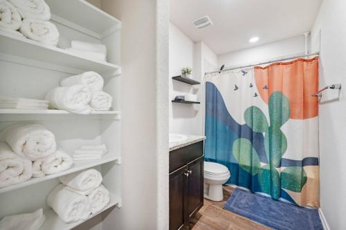 a bathroom with a toilet and towels at Modern Western 5BR Retreat! BMT SeaWorld Riverwalk Alamo in Von Ormy