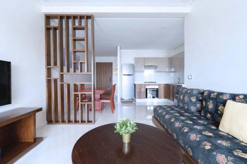 a living room with a couch and a table at Détente en Famille, Piscine, Plage à Proximité in Bouznika
