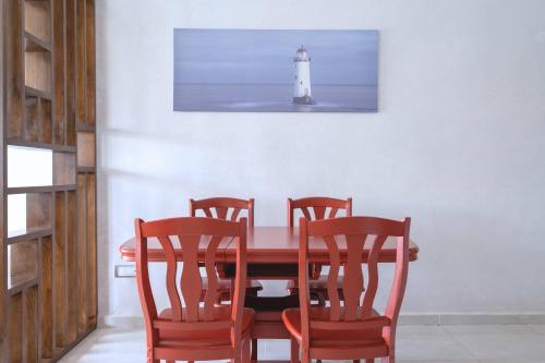 a dining room with a table with four chairs and a lighthouse at Détente en Famille, Piscine, Plage à Proximité in Bouznika