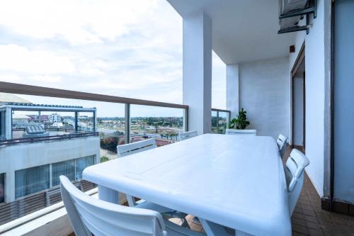 a white table and chairs on a balcony at Détente en Famille, Piscine, Plage à Proximité in Bouznika