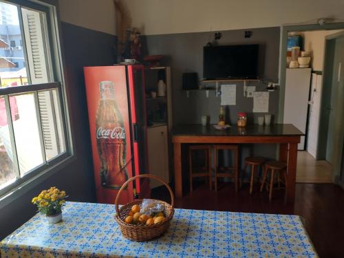 a kitchen with a table with a basket of fruit at Pensão da Su in Caxias do Sul