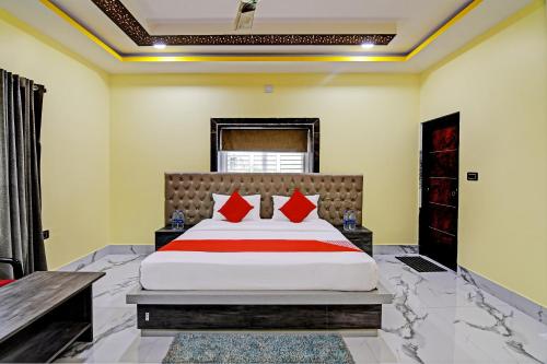 a bedroom with a large bed with red pillows at Hotel O SRI SAI PALACE in Bārang
