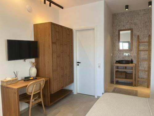a room with a desk and a tv on a wall at Salvia di Astypalea in Livadi Astypalaias