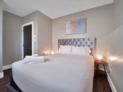 a bedroom with a large white bed with a silver headboard at Comfortable 3BR Getaway in Riverview