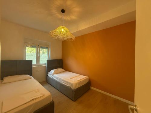 a bedroom with two beds and a chandelier at IRIA Apartment 1 & 2 in Golem
