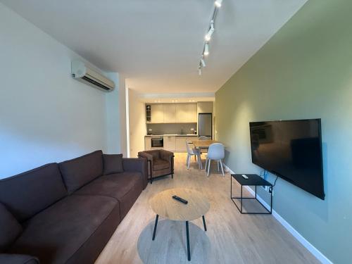 a living room with a couch and a flat screen tv at IRIA Apartment 1 & 2 in Golem