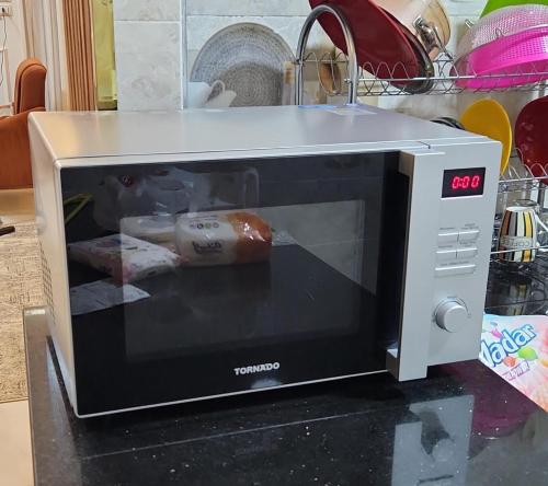 a microwave sitting on top of a counter at Sedra Beautiful House in Madinat Al Ashir min Ramadan