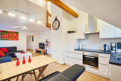a kitchen and a living room with a table in a room at Müller s Ferienhäusle UG in Vogtsburg