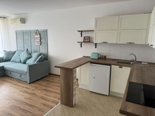 a kitchen and living room with a couch and a table at Atia Resort in Chernomorets
