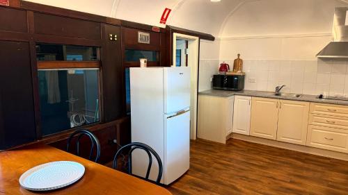 a kitchen with a white refrigerator and a wooden table at Daintree Beach Resort in Wonga