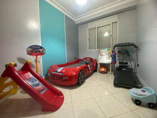 a childs room with a toy car and a slide at Comfortable & Well-Located Apartment Near Rabat in Oulad Akkou