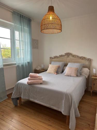 une chambre avec un lit avec deux serviettes dessus dans l'établissement L œil de sangatte, à Sangatte