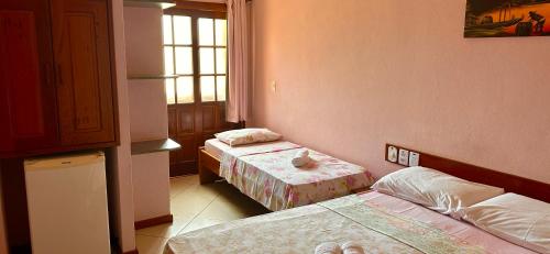 a room with two beds and a window at Pousada Maravista in Anchieta
