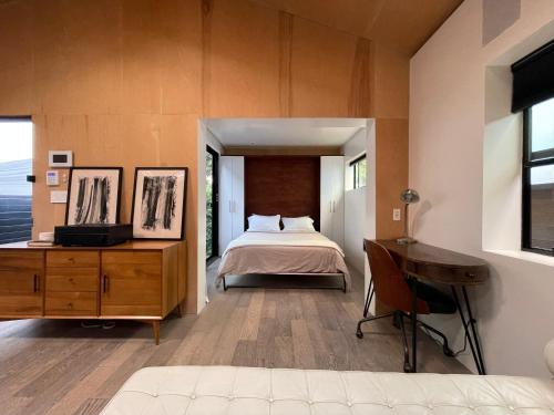 a bedroom with a bed and a desk and a television at Private Venice Beach Luxury Bungalow, Outdoor Tub, Steps To Ocean & Abbot Kinney in Los Angeles