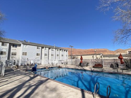 a swimming pool in front of a building at River Canyon Lodge in Moab