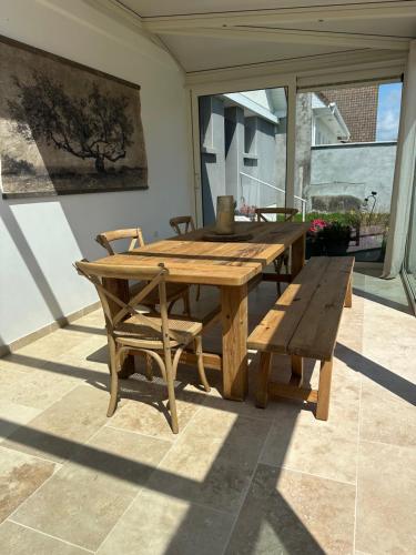 a wooden table and bench on a patio at L œil de sangatte in Sangatte
