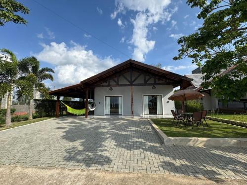 una casa bianca con patio e ombrellone di Casa de Campo em condominio ad Areia