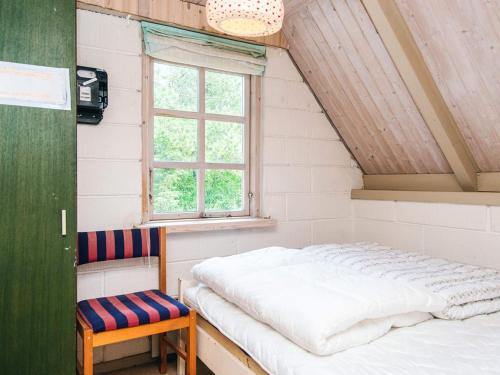 a room with a bed and a window and a chair at 5 person holiday home in Ringkøbing-By Traum in Nørby