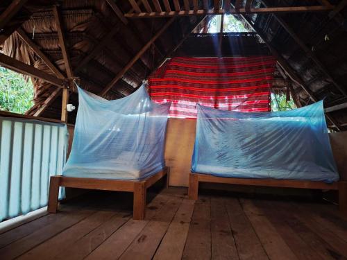 a tent with two benches on a wooden floor at Casa do Xingú in Leticia