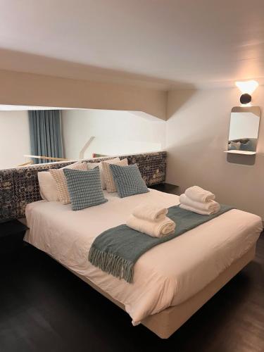 a bedroom with a large bed with towels on it at Exclusive apartment in Lisbon in Bicas