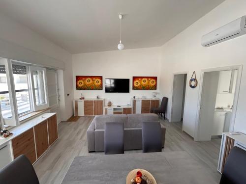 Una sala de estar con un sofá y un comedor. en Villa PO, en Torre Santa Sabina