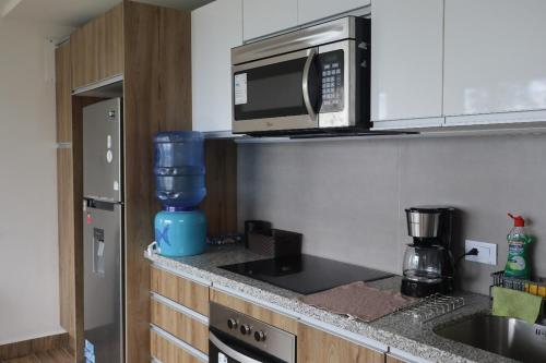 a kitchen with a microwave and a counter top at Apartment in Tumbaco - Ilalo in Hacienda Rumihuaicu