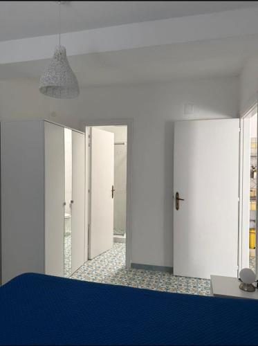a room with white doors and a blue table at Perla Bianca Holiday Home, Forio in Forio d'Ischia