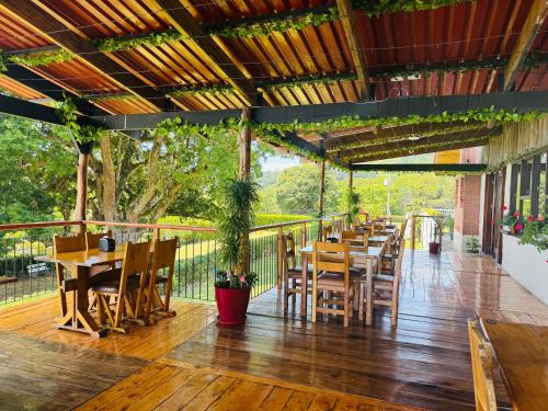 a restaurant with tables and chairs on a wooden deck at hotel cypresal miradory restaurante in Barva