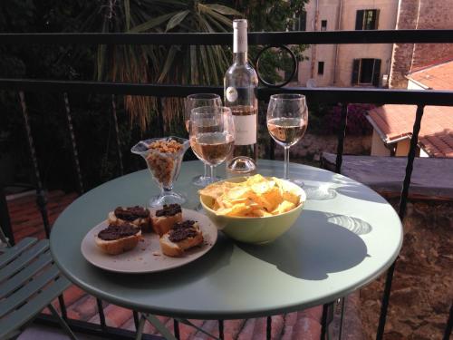 une table avec une assiette de nourriture et des verres de vin dans l'établissement Suquet Charm, à Cannes