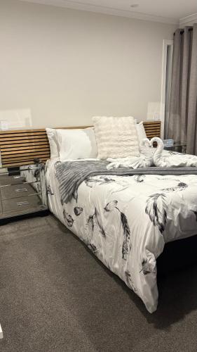 a bedroom with a large bed with white sheets at Kakianau Retreat, Luxury Waterfront Apartments in Portobello
