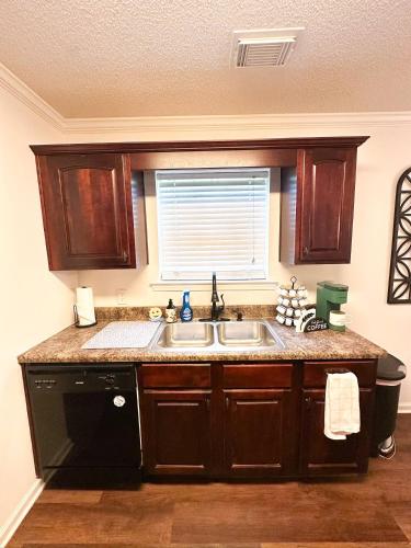 a kitchen with a sink and a window at Crescent Gardens-3 Miles from UA in Tuscaloosa