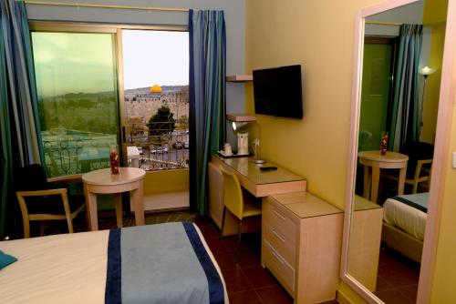 a hotel room with a bed and a view of a city at Holy Land Hotel in Jerusalem