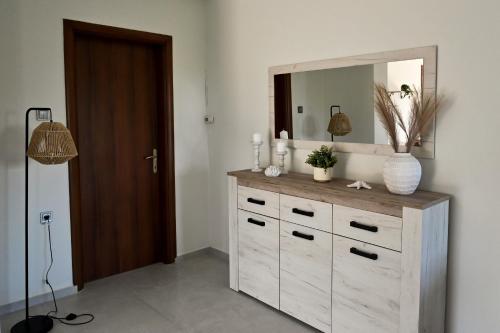 a dresser with a mirror on top of it at PanMaria Sea View Garden Flat in Volos