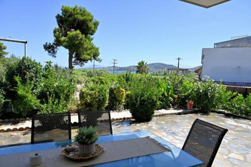 a patio with a table and chairs and a vineyard at PanMaria Sea View Garden Flat in Volos