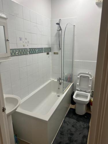 a bathroom with a tub and a toilet and a sink at The Retreat On Retreat Road in Southend-on-Sea