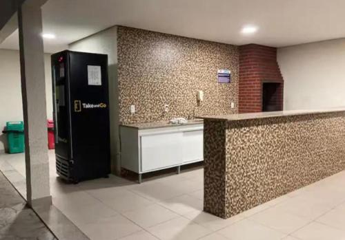 a large kitchen with a refrigerator and a counter at SPAZIO GOMES E COSTA vip in Cabedelo