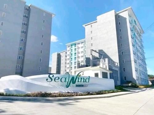 a sign in front of two tall buildings at Cozy place at seawind condo, Davao City Near davao airport SMX Sm lanang Sasa wharf in Davao City