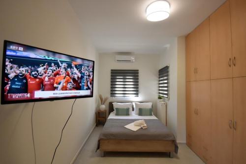 a bedroom with a tv hanging on the wall at PanMaria Sea View Garden Flat in Volos