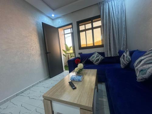 a living room with a blue couch and a table at Atalanta Surf House in Imsouane